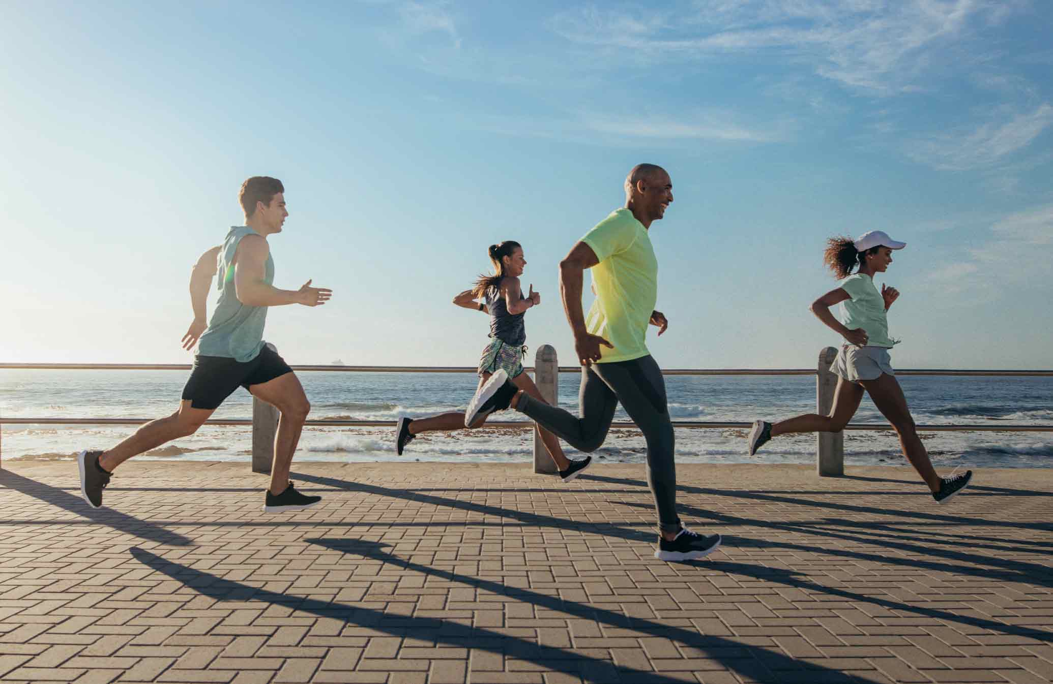 Diverse group of four jogging by the ocean